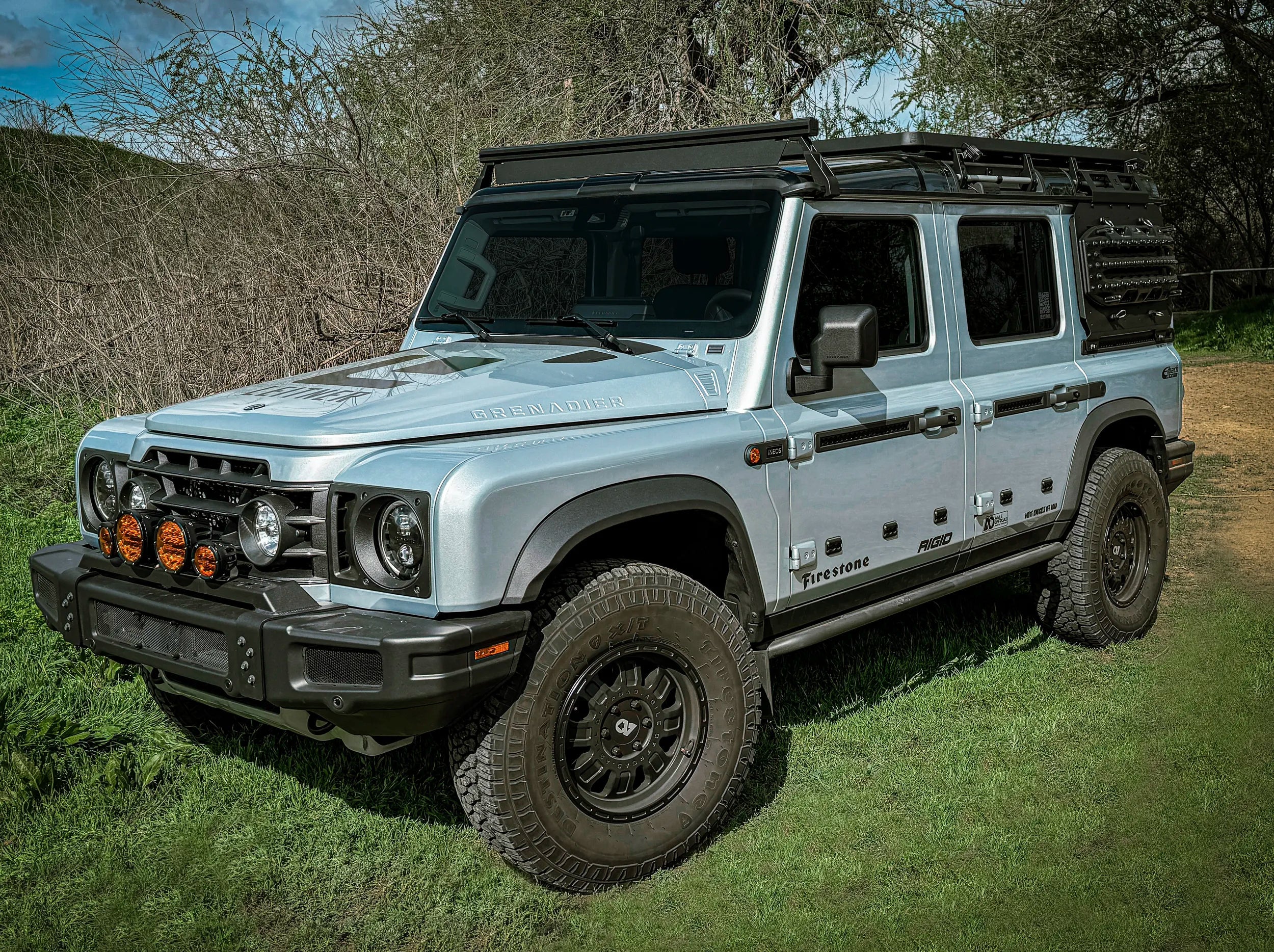 ELDORET BLUE GRENADIER WITH FRONT LOAD BAR AND 3/4 GRENADIER ROOF RACK OUTSIDE ON GRASS