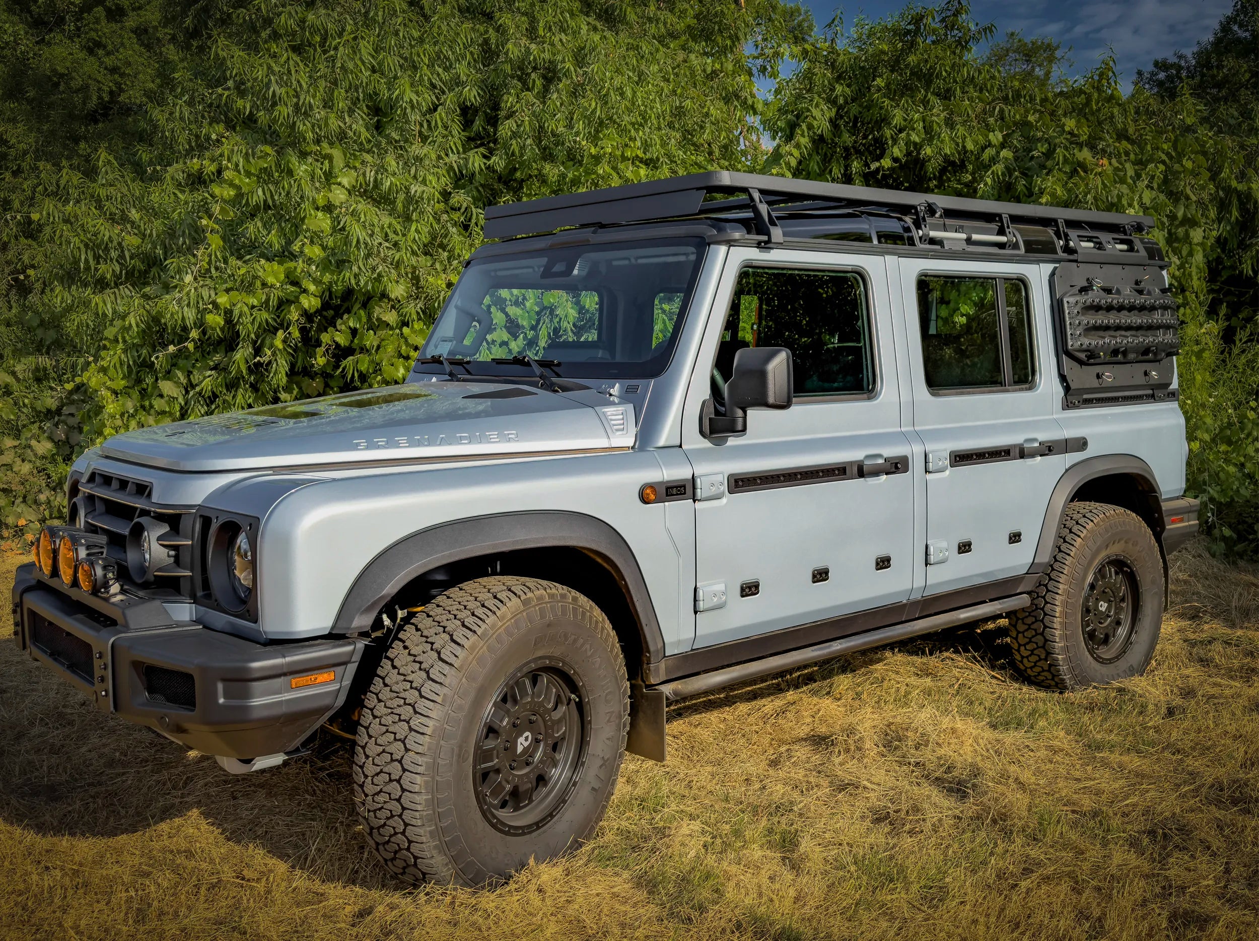 SIDE VIEW OF GRENADIER OUTSIDE WITH ROOF RACK MOUNTED AND WIND DEFLECTER