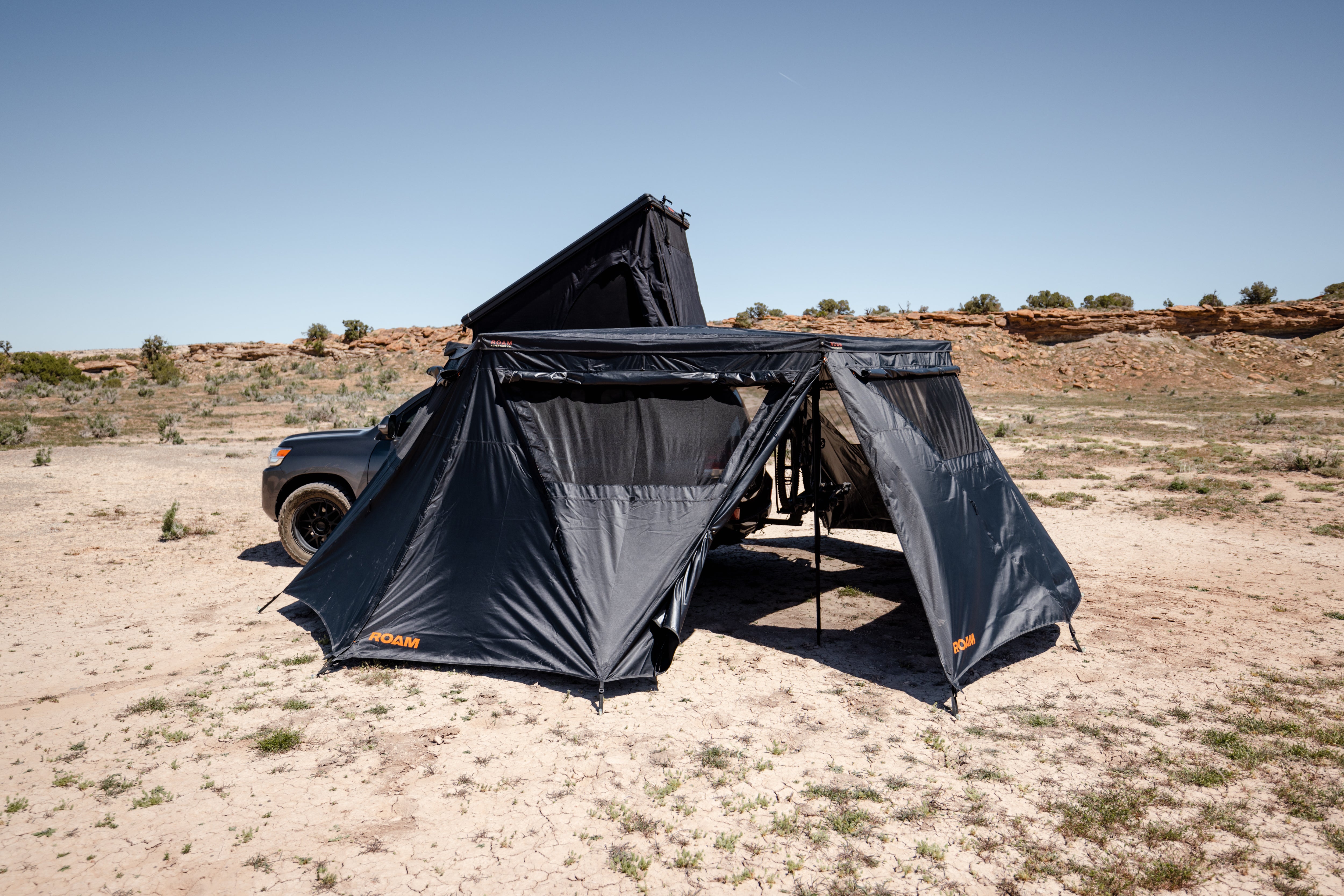 ROAM ARC 270 awning walls blocking wind at a desert camp