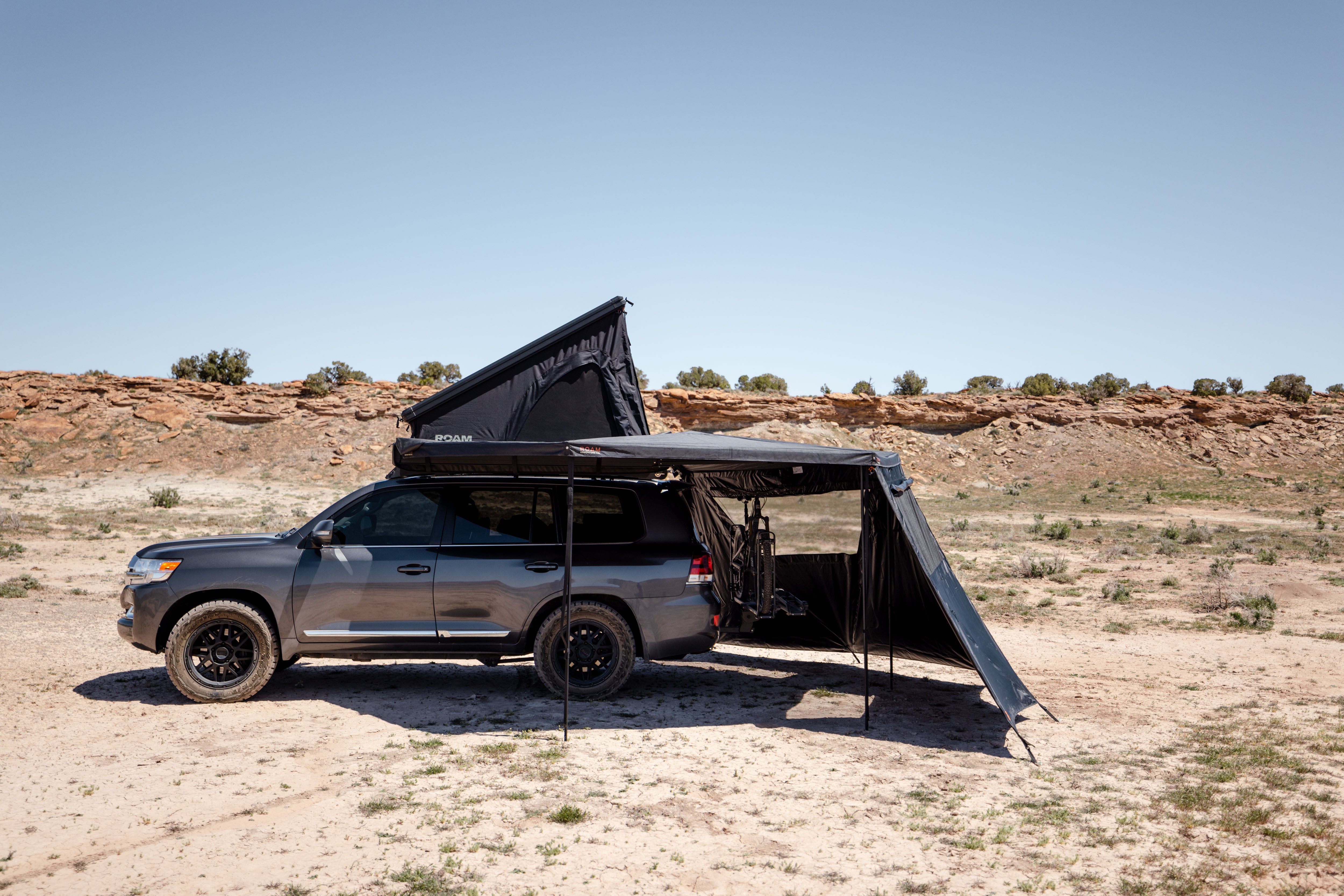 ROAM ARC 270 awning wall kit set up beside an overland vehicle