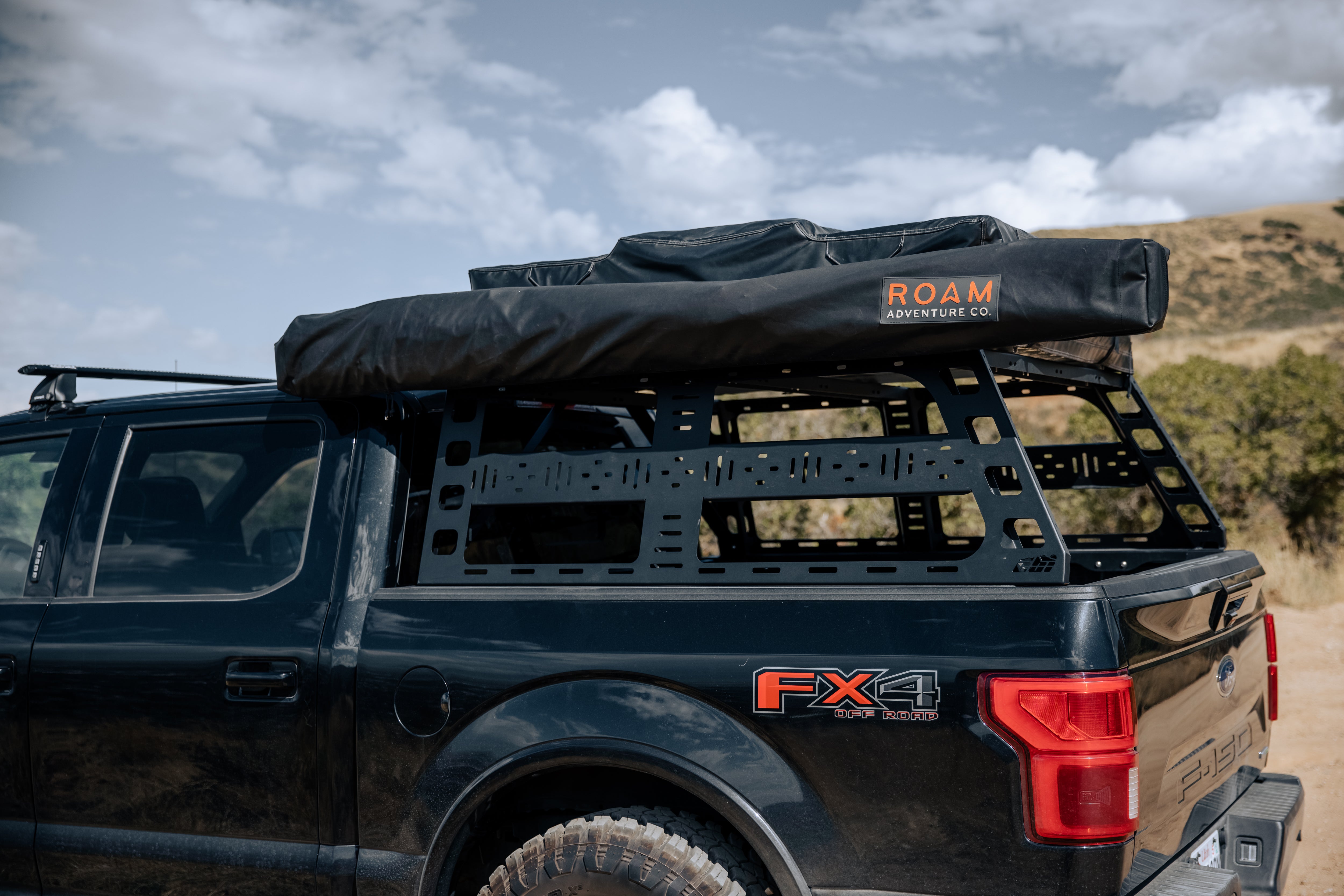 Wide view of a ROAM ARC 270 awning at a campsite