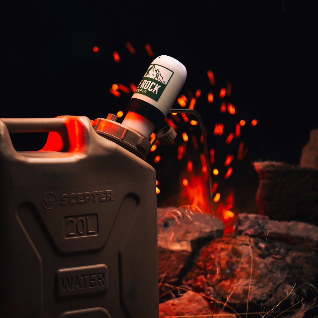 Lone Rock Concepts water pump on a tan 20L Scepter water can with campfire sparks behind at night