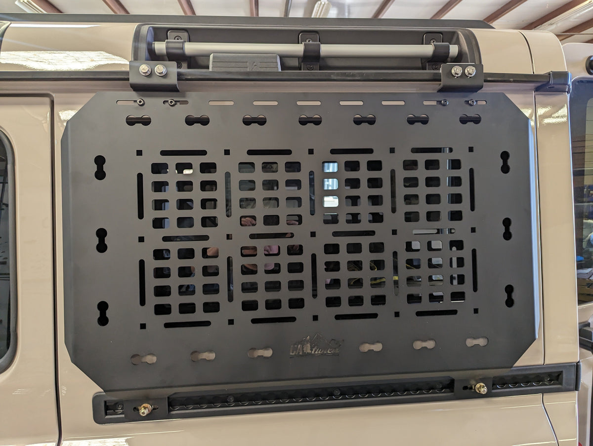 Empty black MOLLE panel installed on the side of a tan SUV