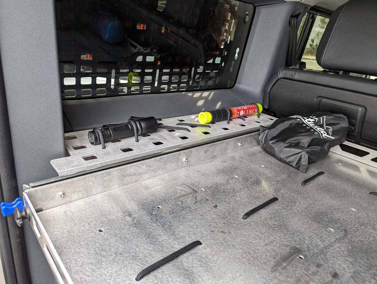 Metal shelf with a MOLLE panel along the side wall of the cargo area