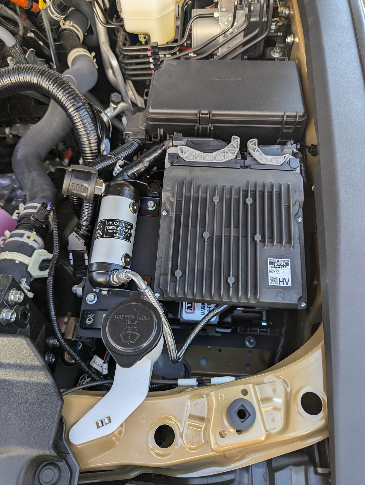 Compressor installed in the engine bay, close view