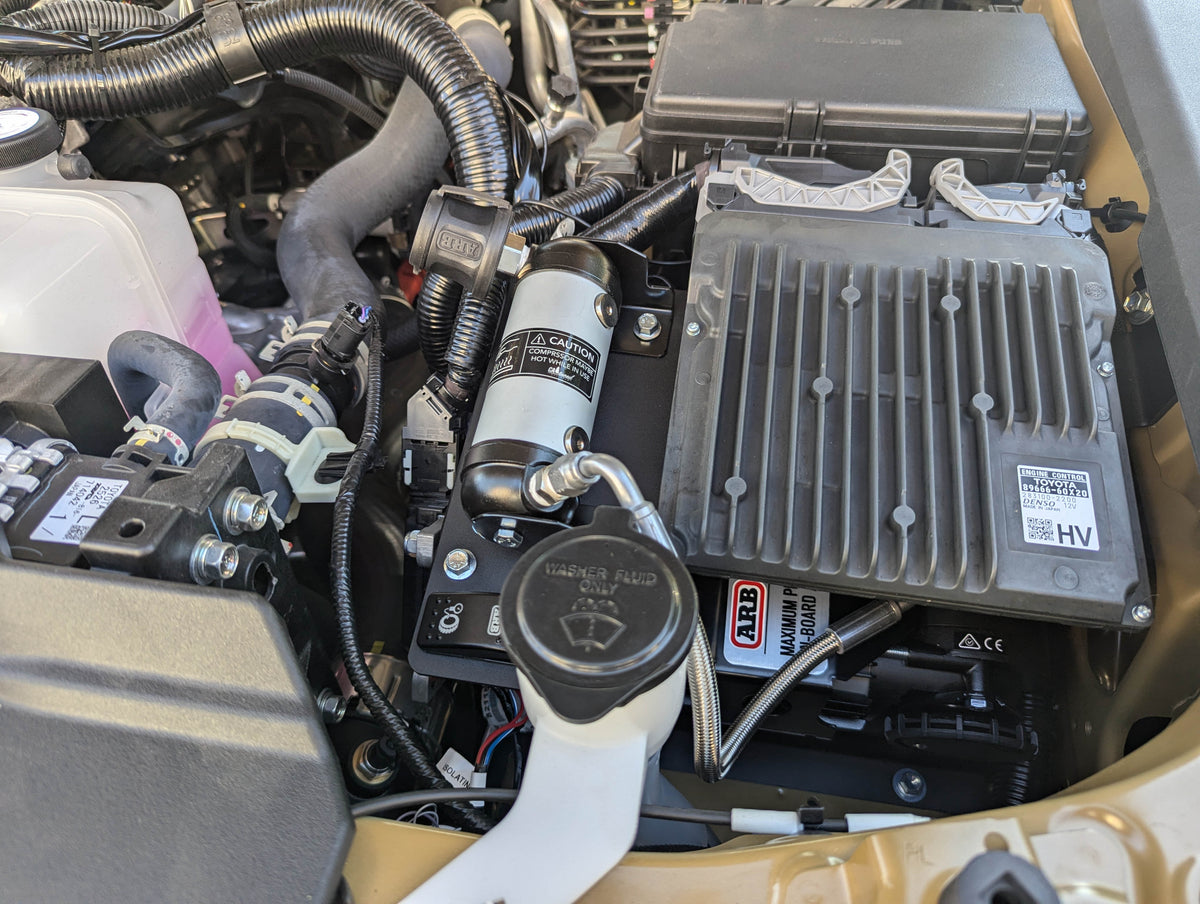 Close view of the installed compressor next to a fluid reservoir
