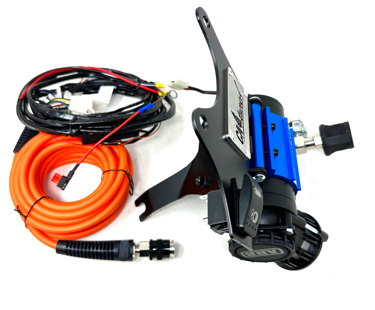 Compressor, black mount bracket, orange hose and wiring harness shown together