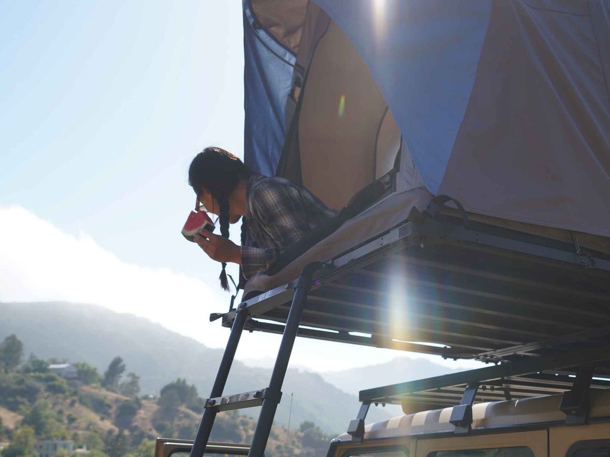 C6 Rev Rooftop Tent X (Element) – person at the open tent doorway on a roof platform