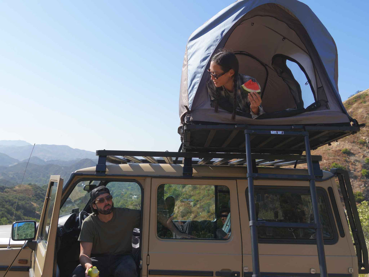 C6 Rev Rooftop Tent X (Element) – person at the tent window on a vehicle roof