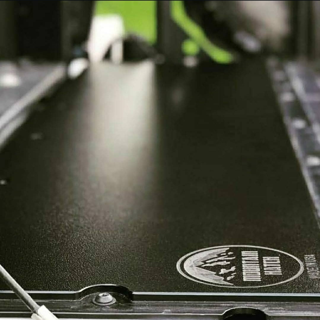Edge detail of a black Mountain Hatch tailgate table showing 1/2-inch HDPE thickness and stamped logo (material sample photo)