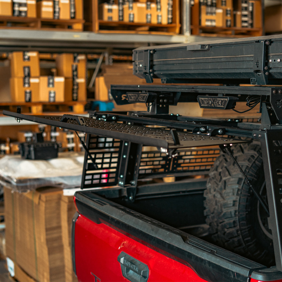 Rear hatch lifted open above the tailgate of a red truck