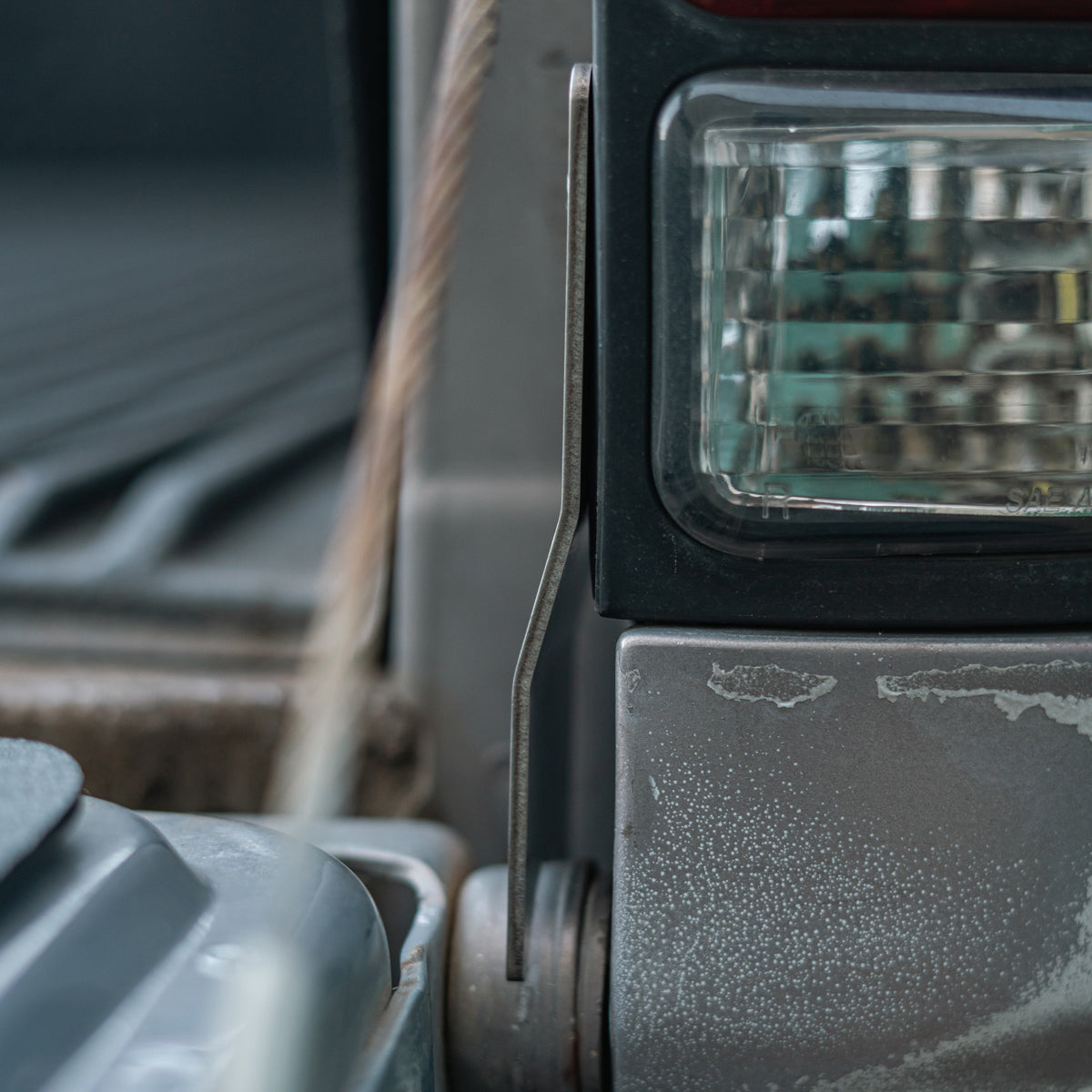 Side view of the tailgate theft protector bracket covering the hinge beside the tail light