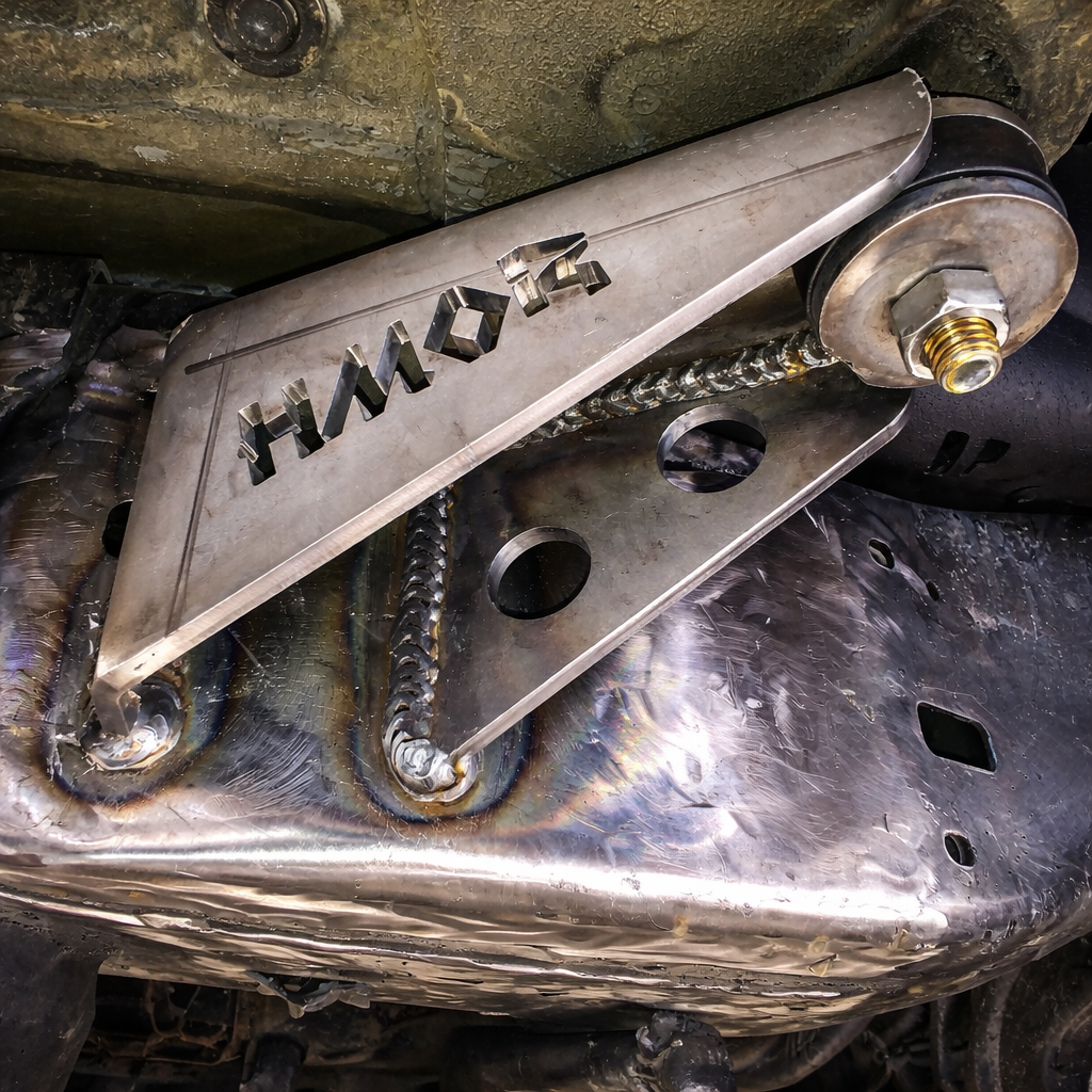 HMOR body mount relocation bracket welded to a Tacoma frame with bushing installed