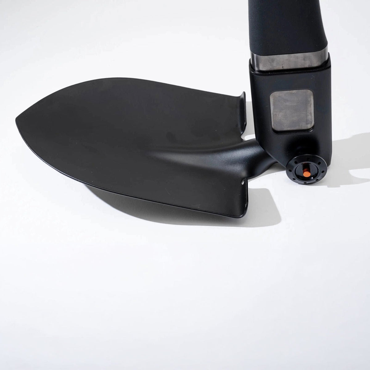 Close-up of the Adventure Mate shovel blade and the handle connector with a metal plate and orange button