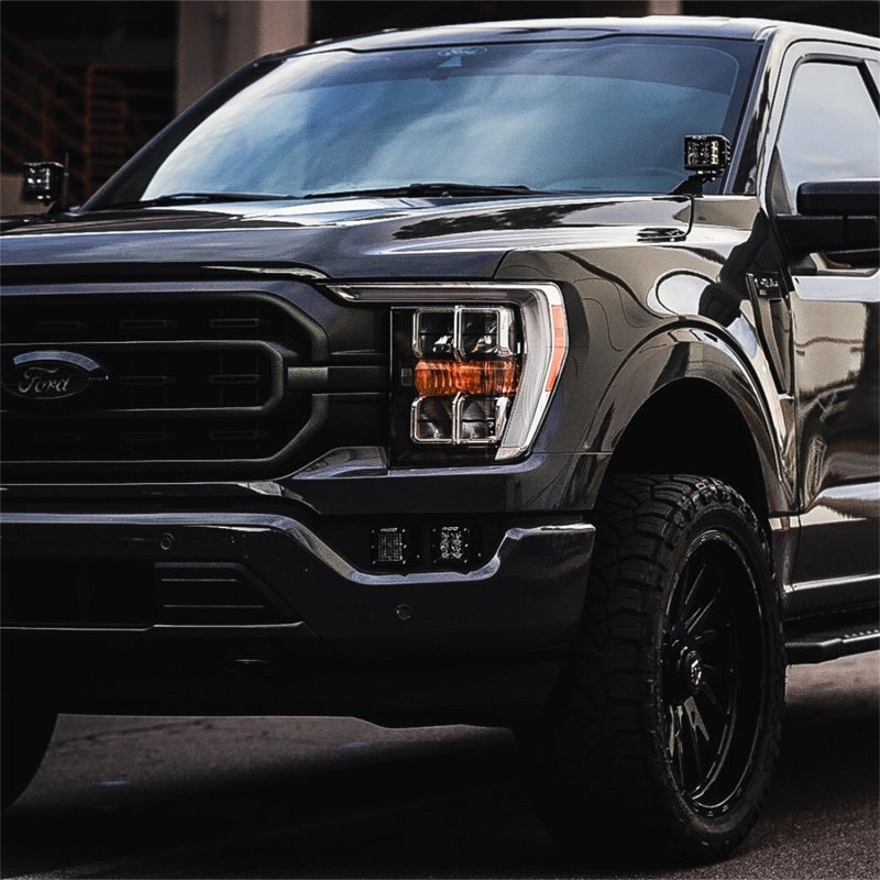 Front view of a 2021+ Ford F-150 with Rigid D-Series fog lights lit