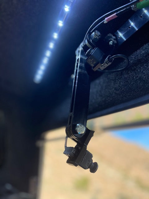 Pivot arm camera mount under a topper roof beside LED bed lighting