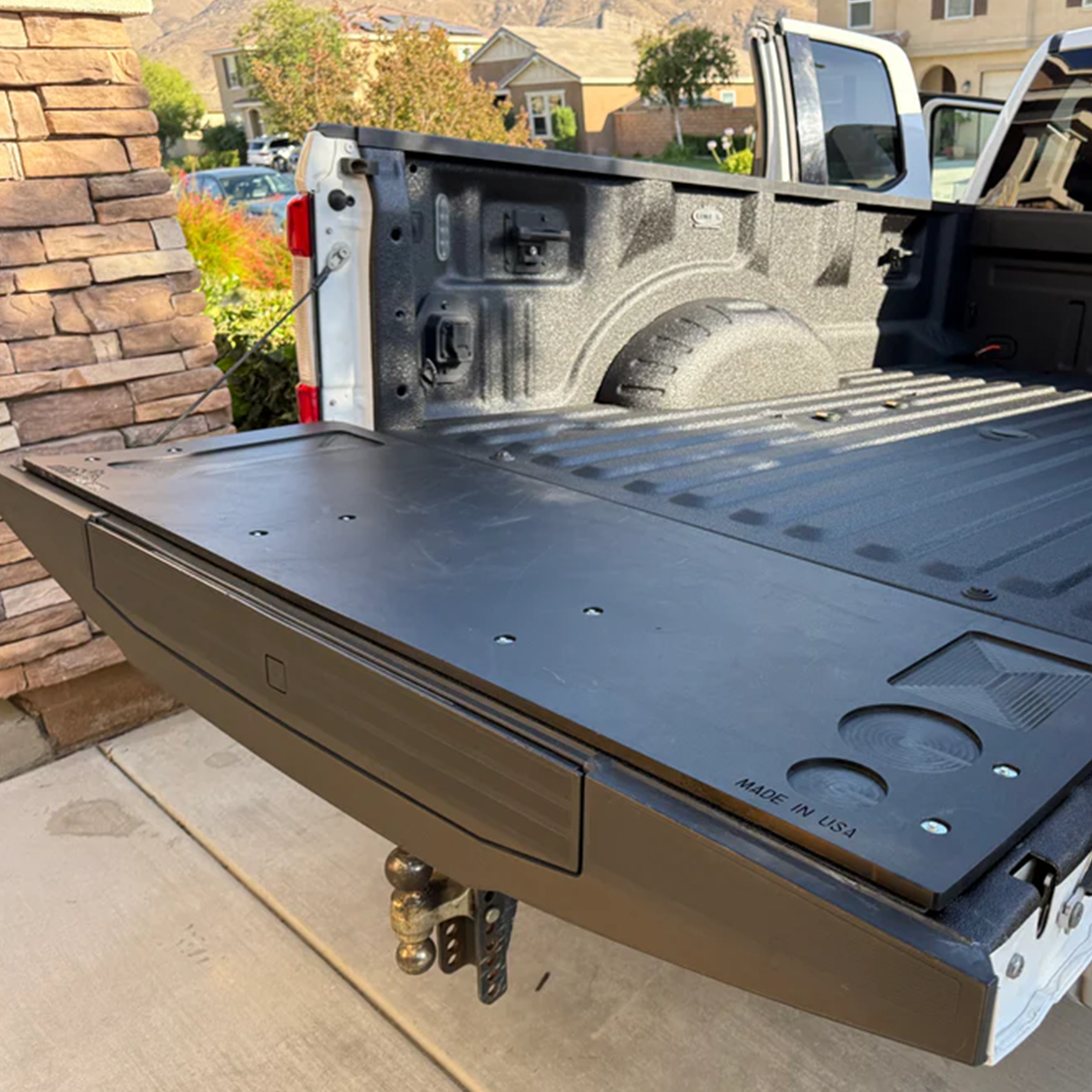 Mountain Hatch tailgate table installed on a 2017-2022 Ford Super Duty tailgate with spray-in bedliner, recessed drink holders at right