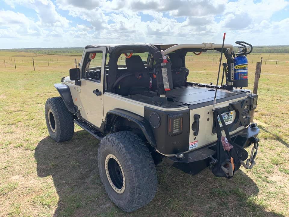 Tan Jeep JK 2-door in a field with the Slipstream enclosure and a PowerTank fitted