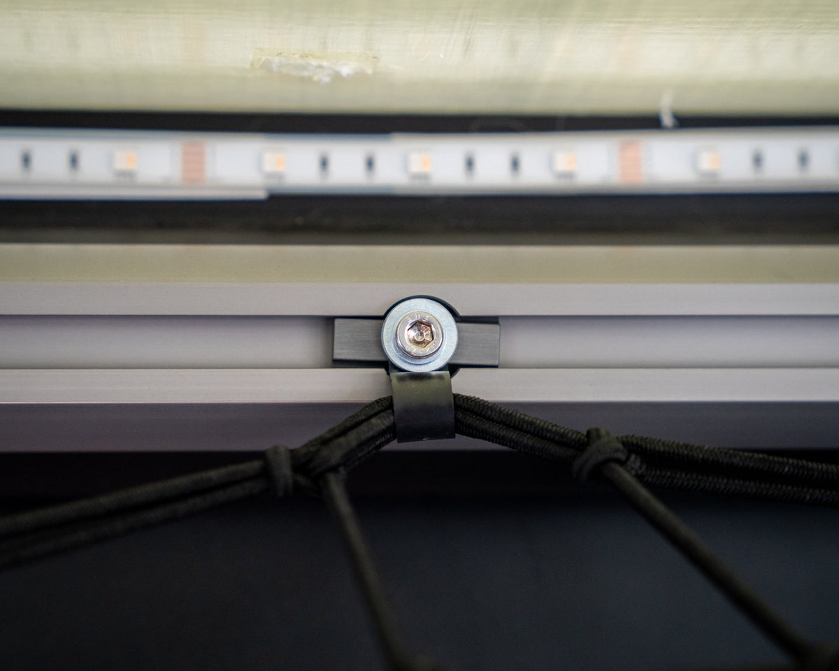 Cargo net tied off to an L-track nut on camper rail