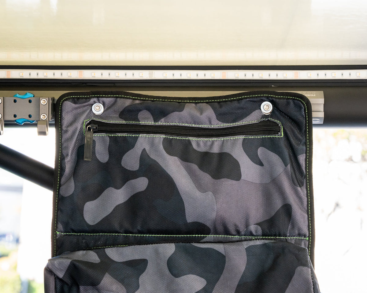 Camo organizer hung flat on L-track nuts under a camper roof