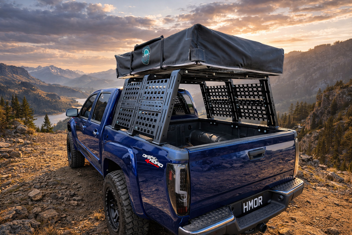 Blue pickup with ROCK-IT rack and tent above a mountain lake at sunset