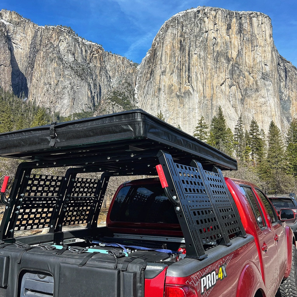 ROCK-IT rack with grab bars on a red Frontier PRO-4X below El Capitan