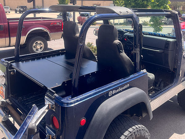 Blue Jeep TJ with the top off and the Ridgeback covering the rear tub