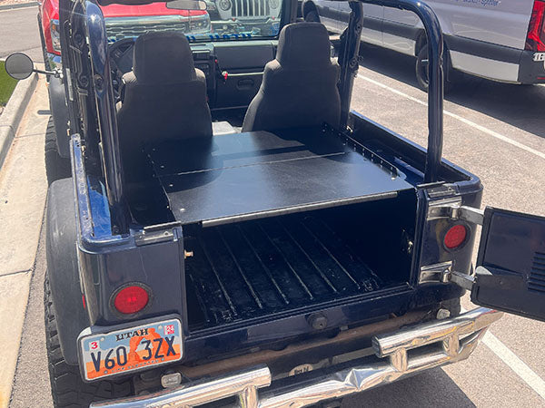 Rear of a blue TJ with the tailgate open showing storage under the Ridgeback