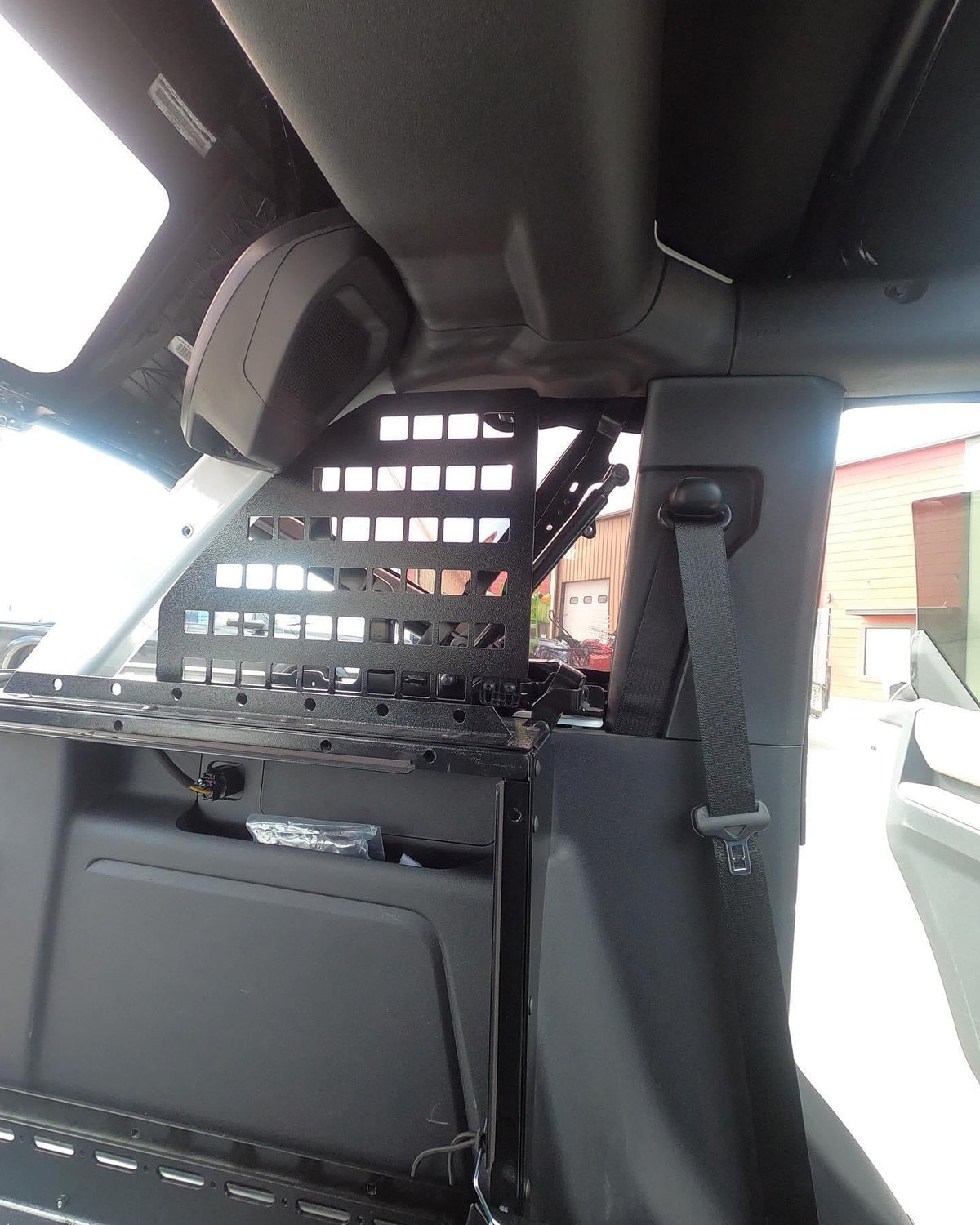 Bronco roll bar MOLLE panel mounted beside the rear seat belt, seen from the side