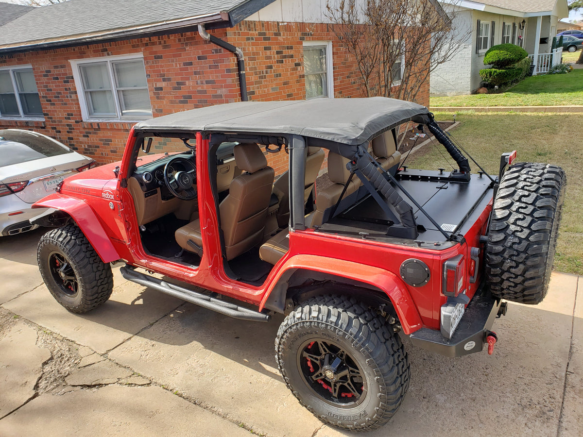 Red Jeep JKU in a driveway, soft top folded back over the Slipstream