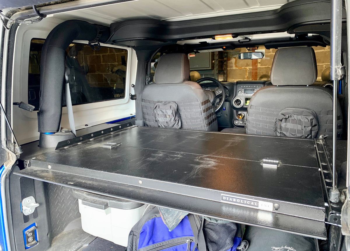 Folding top lifted on a JK Slipstream with a cooler and bags below