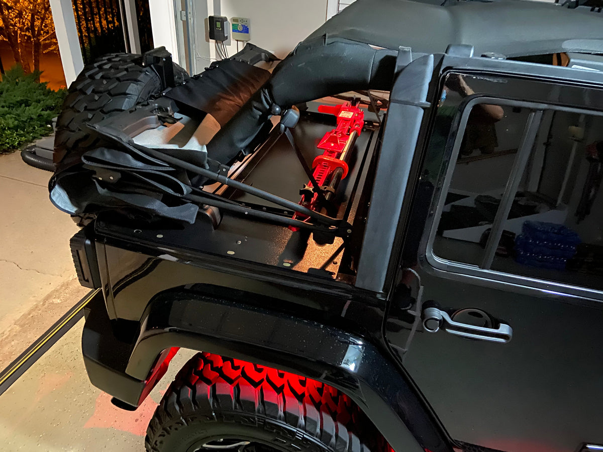 Black JKU with a spare tire and gear strapped on top of the Slipstream