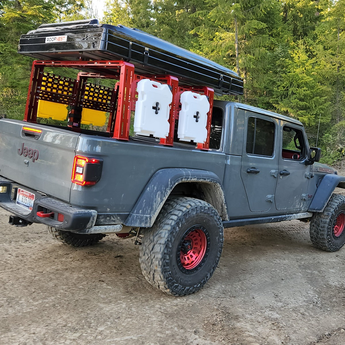 Gladiator with red ROCK-IT rack, white water cans and rooftop tent