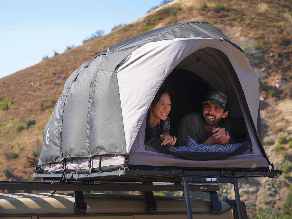 C6 Rev Rooftop Tent X (Eclipse) – couple lying inside the tent on a roof platform