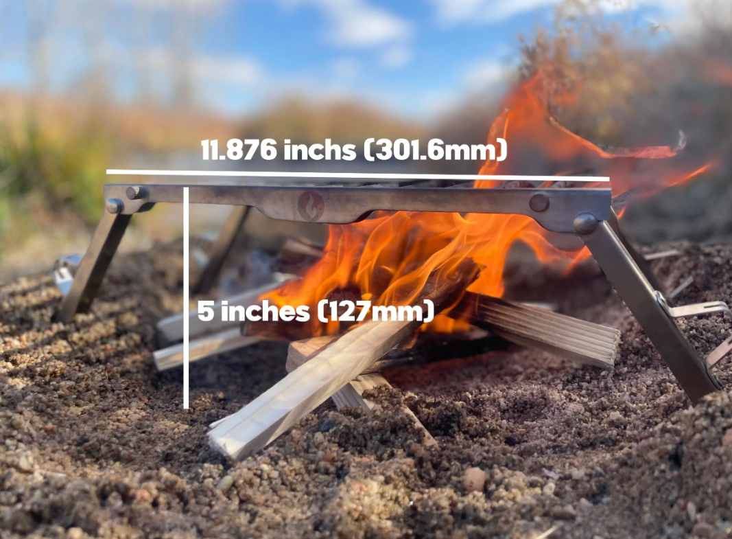 Folding grill grate accessory set over a campfire outdoors, with dimension callouts showing its length and height