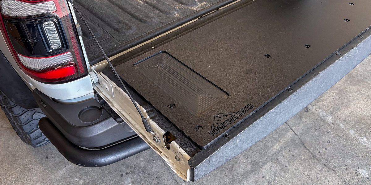 Close-up of the Mountain Hatch panel's recessed utility tray and logo on a Ram HD tailgate