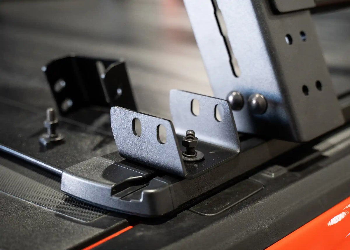 Bed rack mount bracket installed on a retractable bed cover's t-slot track, close-up