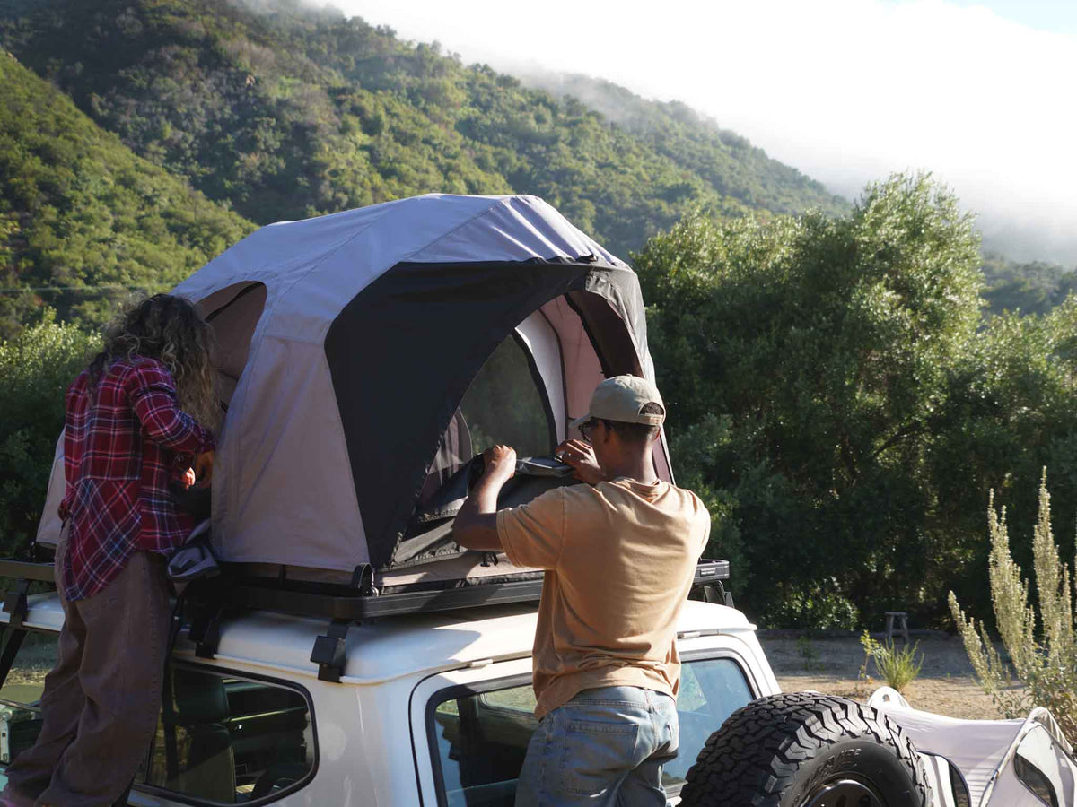 C6 Rev Rack Tent (HellaStorm) – person at the tent on a vehicle roof