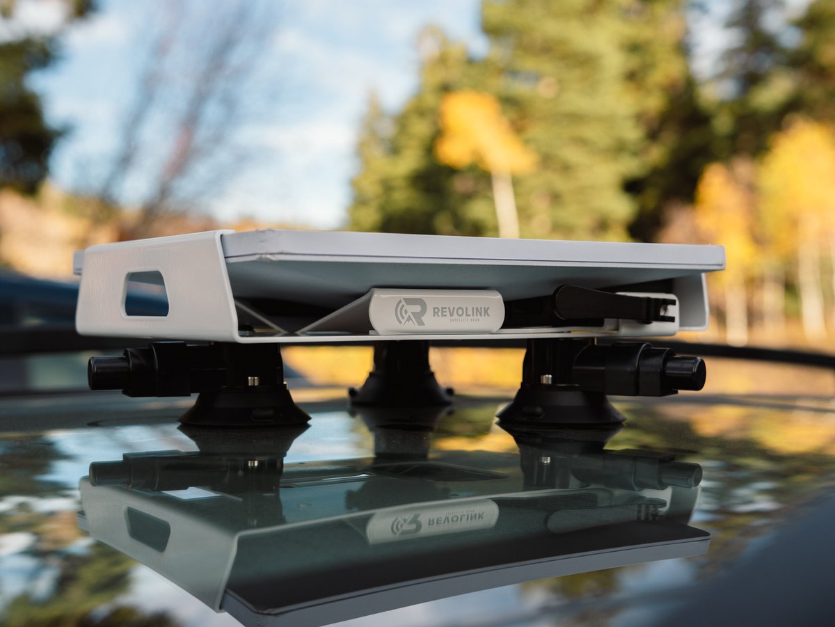 Revolink mount sitting on three suction cups on a glass roof with trees reflected