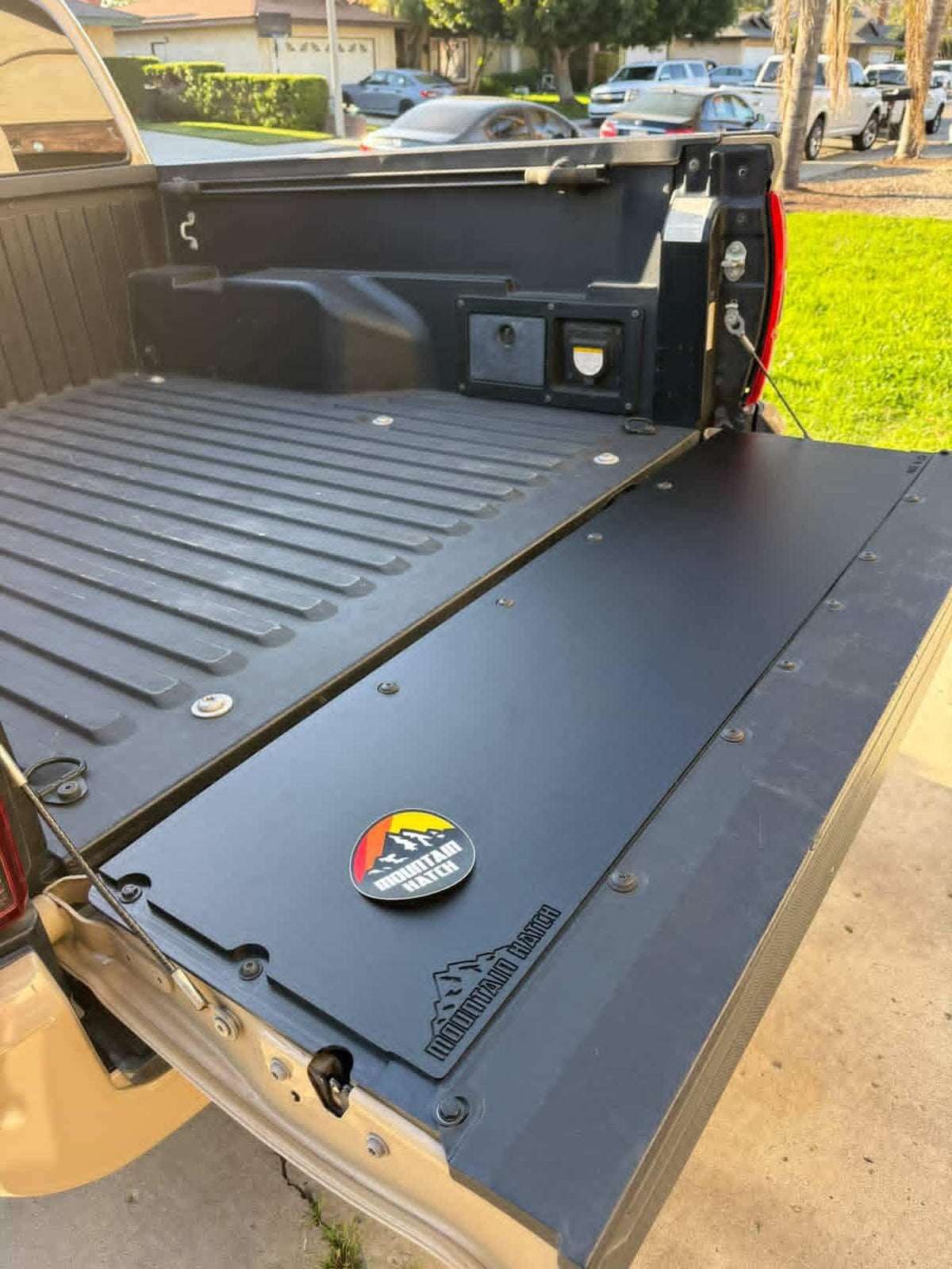 Mountain Hatch flat panel installed on a tan Toyota Tacoma tailgate, viewed from the bed