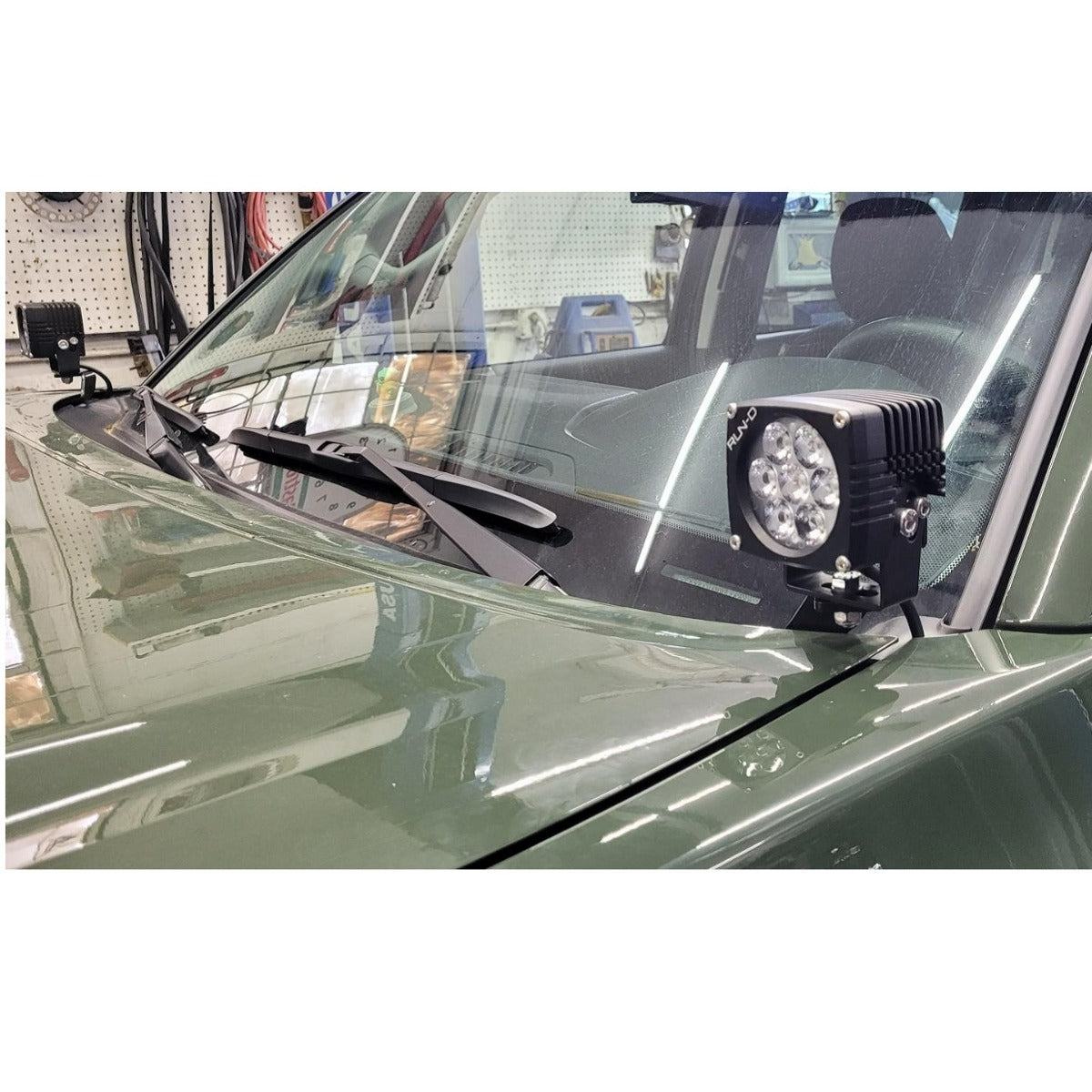 Square LED pod on an HMOR bracket by the Tacoma windshield