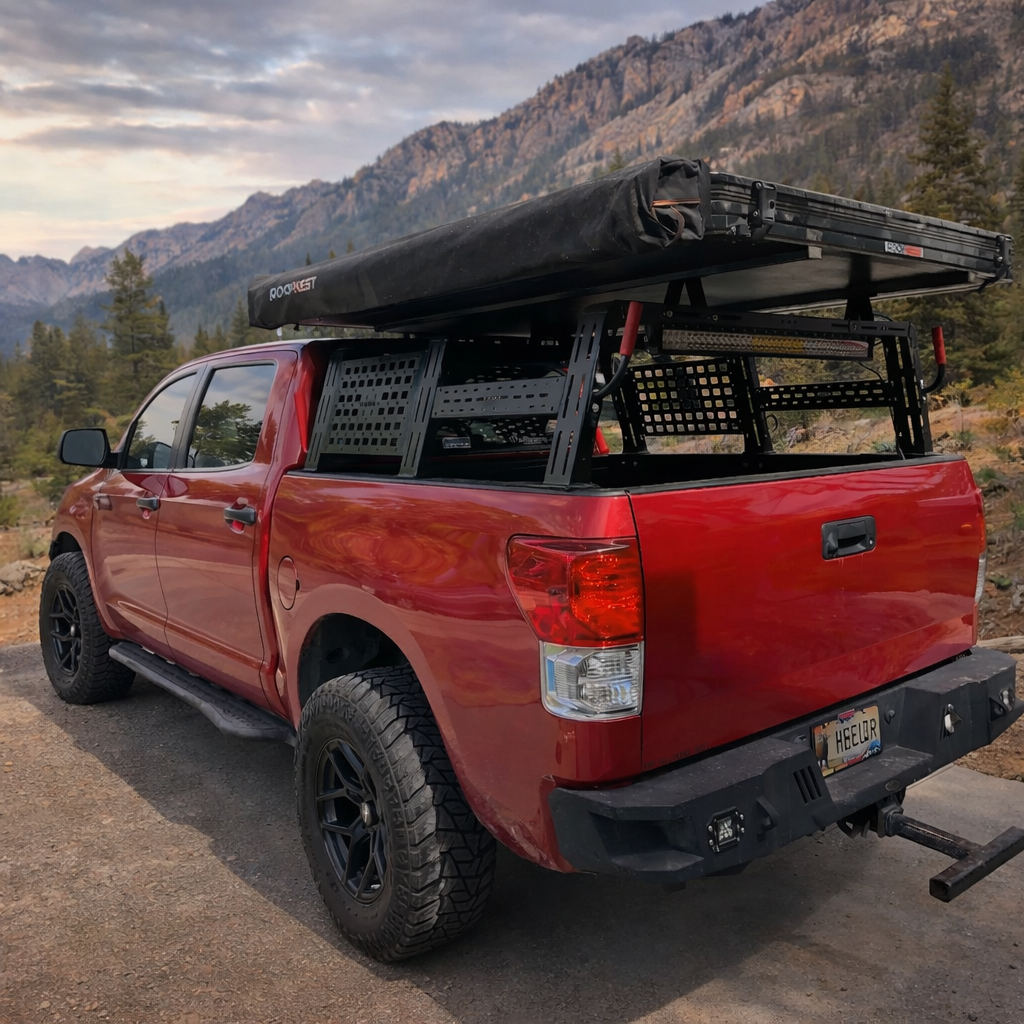 Red Toyota Tundra with HMOR ROCK-IT rack and rooftop tent on a mountain road