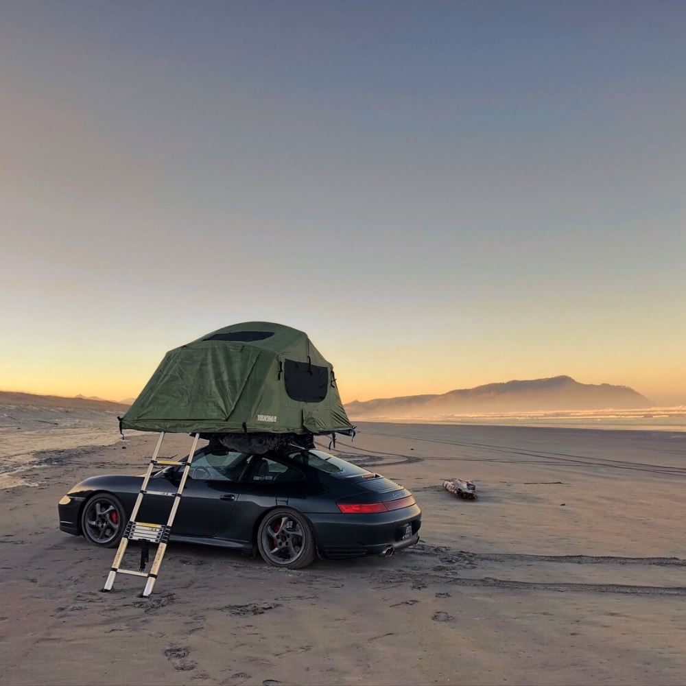 A Porsche With A Roof Top Tent
