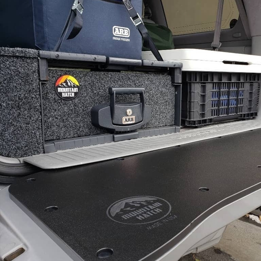 Mountain Hatch tailgate table on a 100 Series Land Cruiser tailgate with an ARB fridge and drawer system in the cargo area