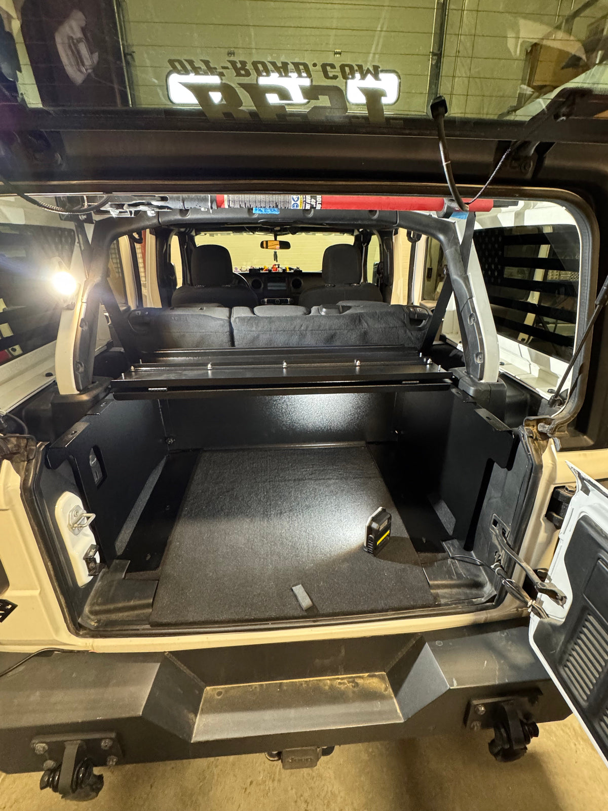 Open tailgate showing the Ridgeback compartment and cargo lights in a JLU