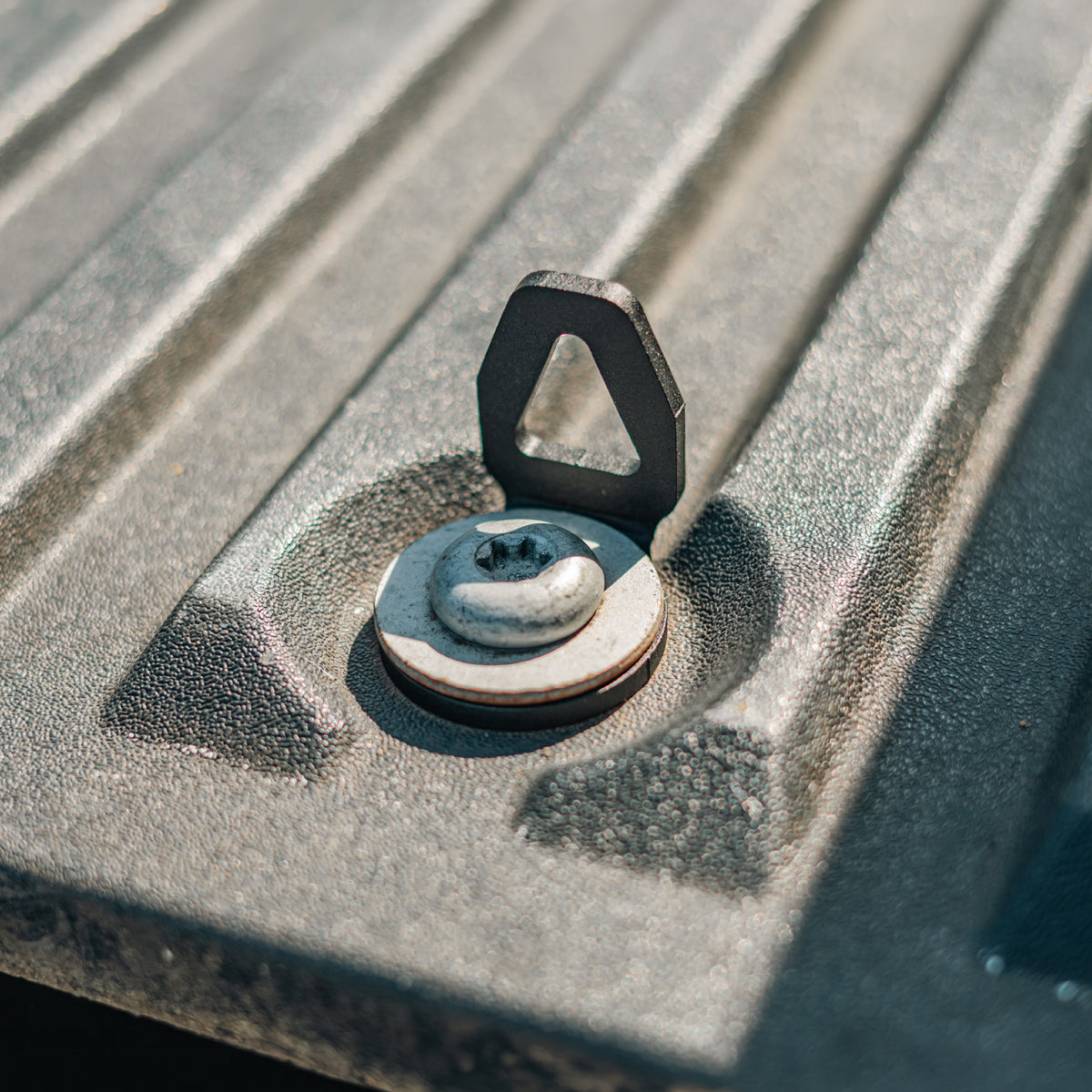 Cali Raised LED bed tie down installed in a truck bed anchor point, open position