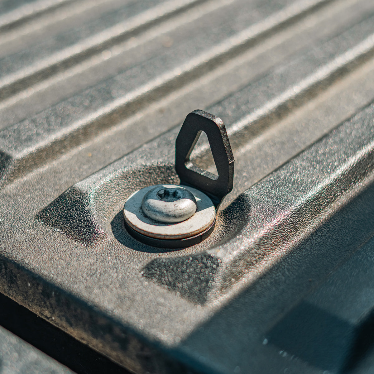 Cali Raised LED bed tie down installed in a truck bed anchor point, angled view