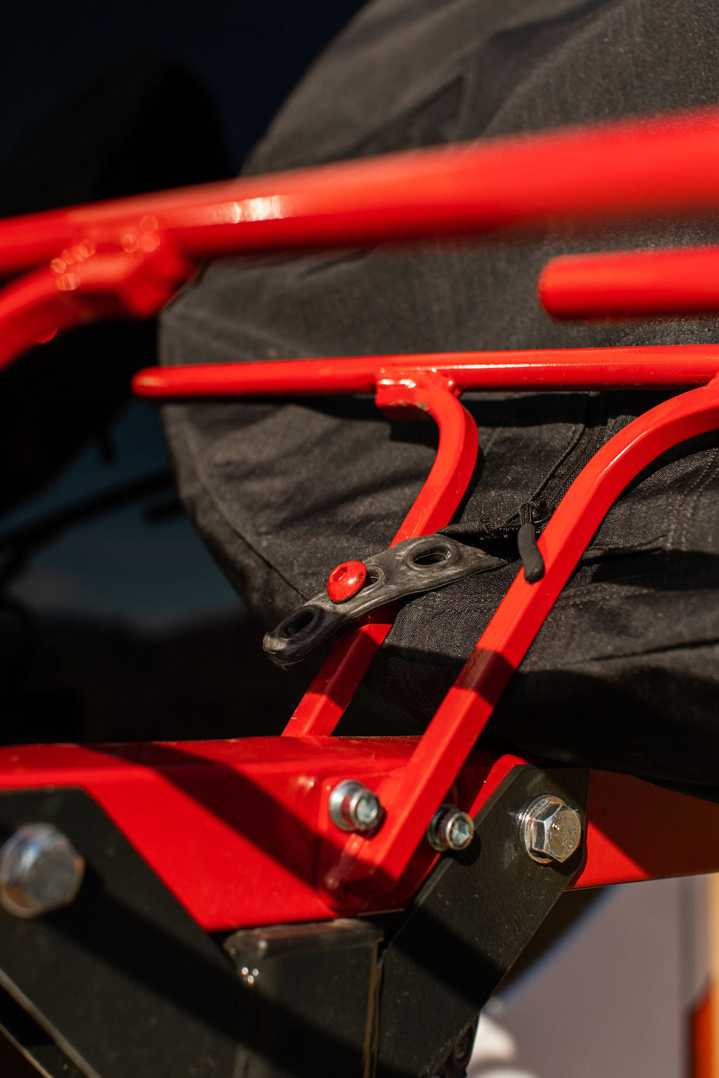 Close-up of a VelociRAX front wheel strap passing through the modified wheel section of the cover