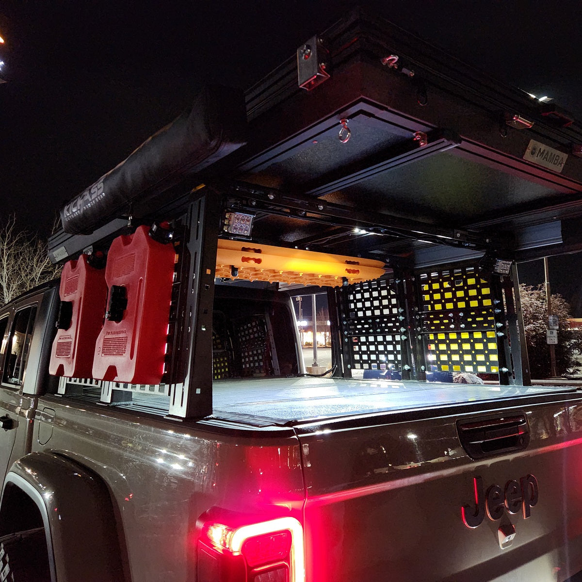ROCK-IT rack lit at night over a Gladiator tailgate
