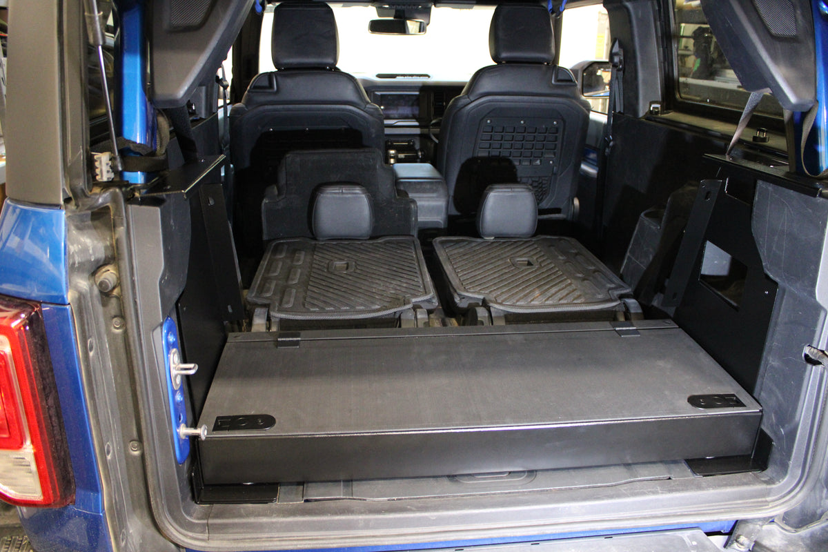 Stage platform level with the folded seats in a blue Bronco 2-door